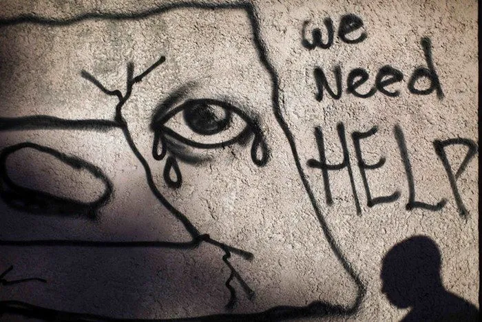 Graffiti cu un ochi care plânge și cuvintele „We need help”